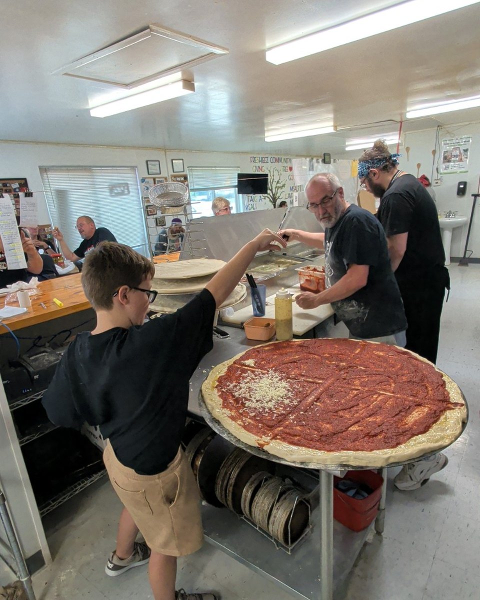 A young GastroMob participant helping make the giant pizza at Freshieez